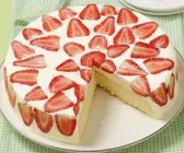 Mascarpone-Erdbeer-Torte auf weißem Teller, angeschnitten