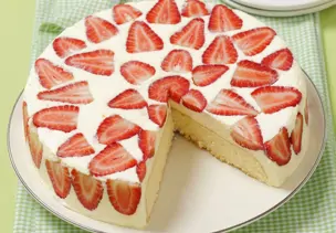 Mascarpone-Erdbeer-Torte auf weißem Teller, angeschnitten