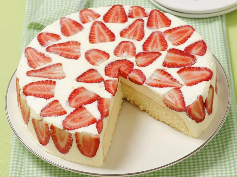 Mascarpone-Erdbeer-Torte auf weißem Teller, angeschnitten