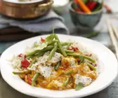 Rotes Thai-Curry mit Jasminreis auf einem weißen Teller