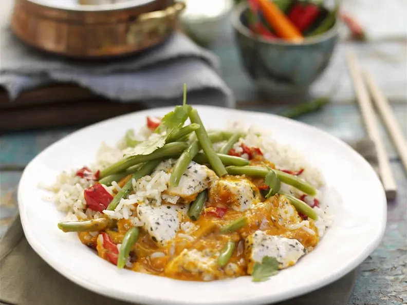 Rotes Thai-Curry mit Jasminreis auf einem weißen Teller