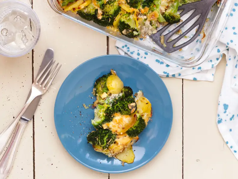 Auflauf mit Brokkoli und Kartoffeln auf blauem Teller