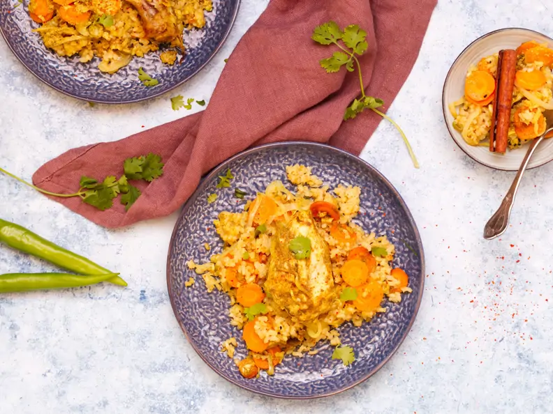 Indisches Biryani-Hähnchen mit Reis auf blauem Teller