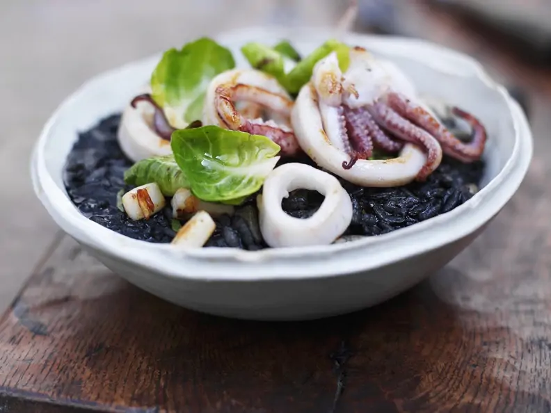 Calamari mit schwarzem Reis und Rosenkohlblättern