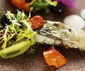 Salat mit Essblüten, Beeren und Makrele