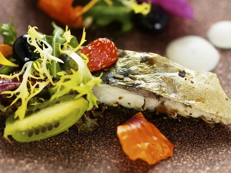 Salat mit Essblüten, Beeren und Makrele