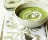 Erbsencremesuppe mit Minze in weißer Schüssel