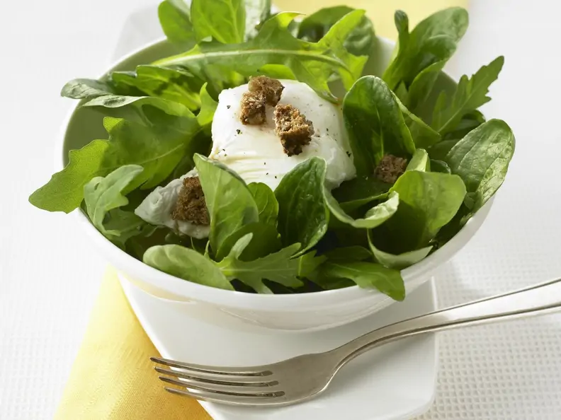 Verlorenes Ei mit grünem Salat