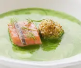 Suppe aus frischen Kräutern mit Lachs und Heringskrokette