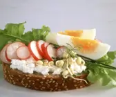 Scheibe Vollkornbrot mit Hüttenkäse, Radieschen, Sprossen und Ei