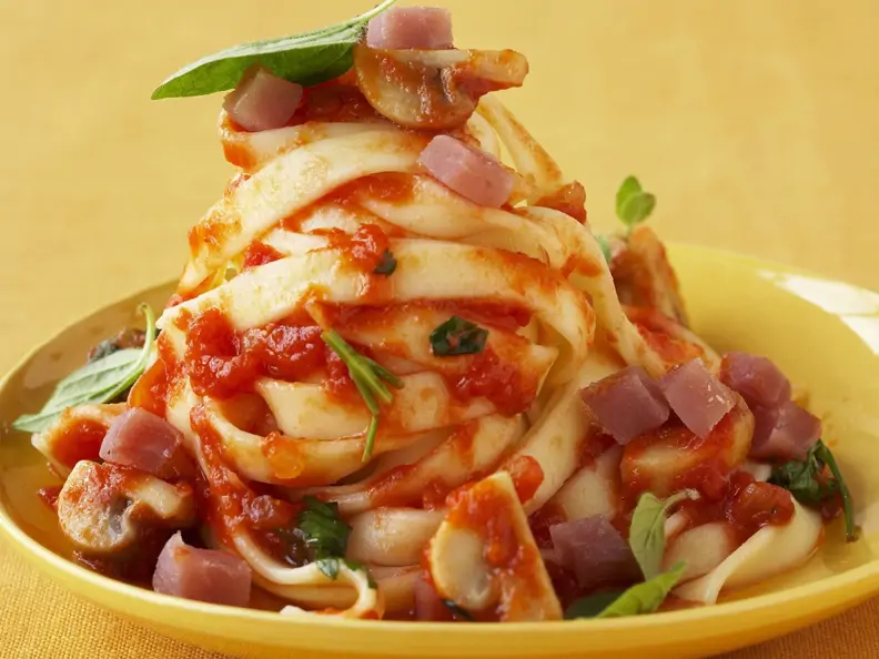 Bandnudeln mit Tomatensauce und Schinkenwürfeln