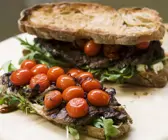 Brote mit Steak, geschmorten Tomaten und Rucola