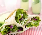 Vegetarische Wraps mit Wasabicreme, Avocado, Salat und roten Zwiebeln