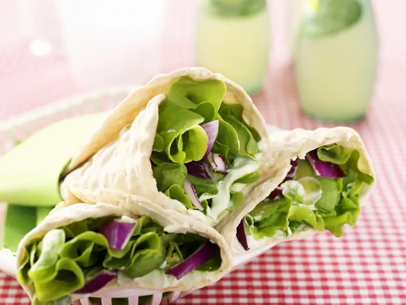Vegetarische Wraps mit Wasabicreme, Avocado, Salat und roten Zwiebeln
