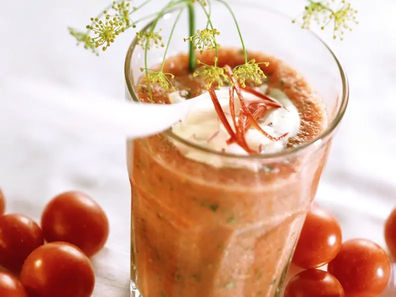 Scharfer Tomatendrink mit Kräutern und Joghurttupfer