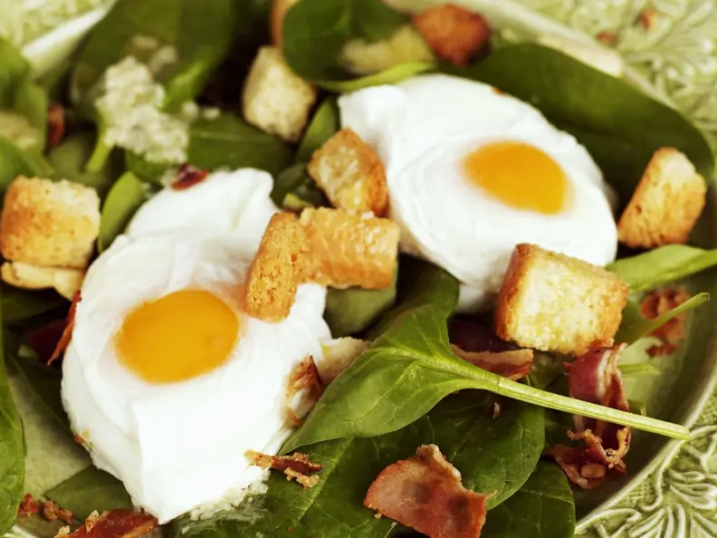Spinatsalat mit rohem Schinken, Croutons und Spiegeleiern