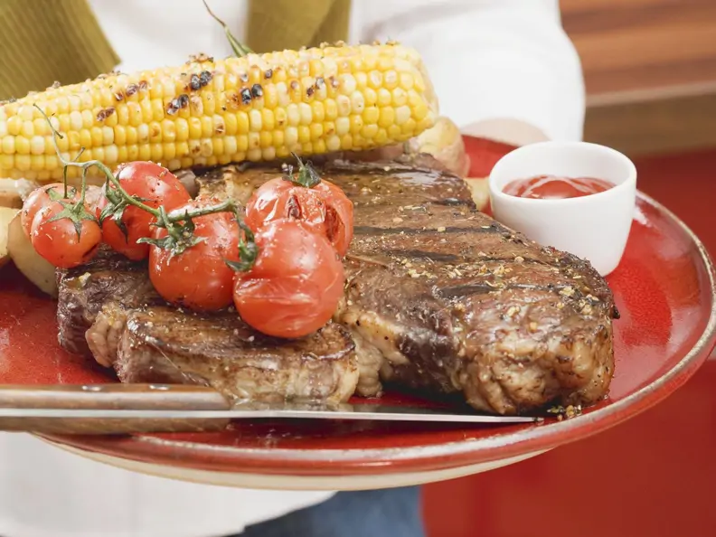 T-Bone-Steak mit gegrilltem Mais und Cherrytomaten
