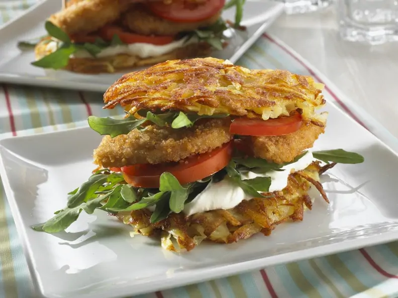 Kartoffelpuffer-Burger mit Frischkäse und paniertem Hähnchen