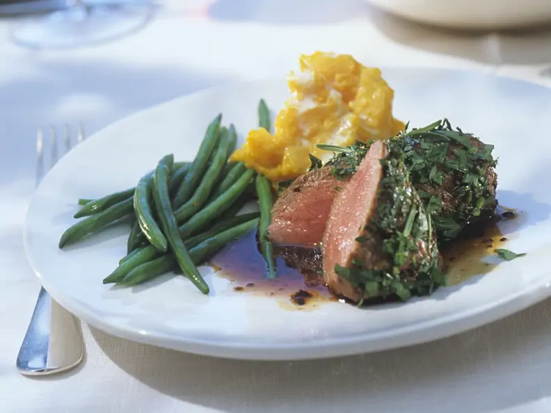 Lammbraten in Kräuterhülle mit grünen Bohnen und Kürbisstampf