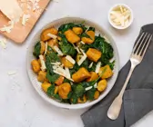 Kürbisgnocchi mit Spinat, daneben Gabel und Parmesan