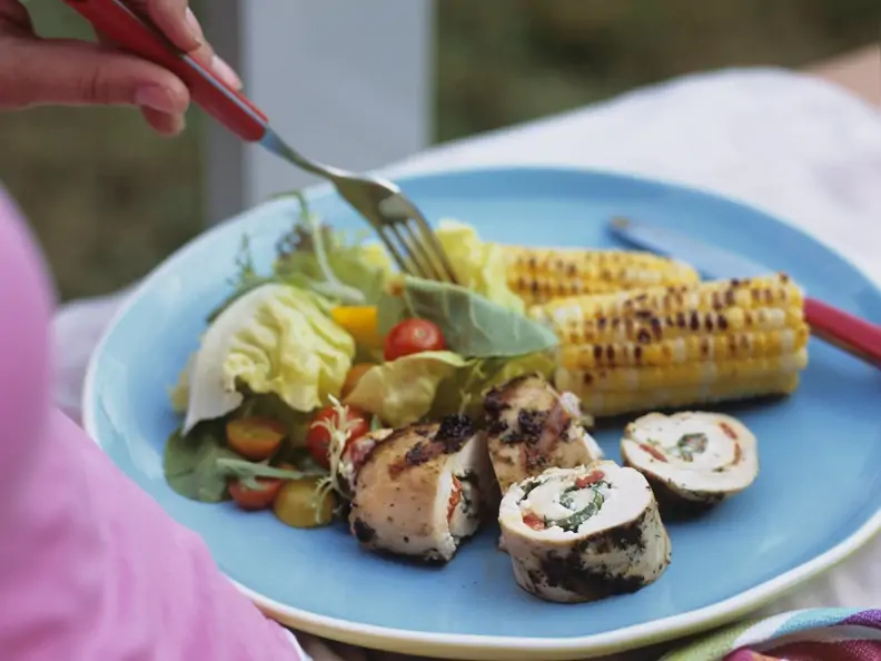 Gegrillte Hähnchenroulade mit gemischtem Salat und Maiskolben