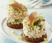 Forellen-Tatar mit Gurke und Lauchzwiebeln auf Pumpernickel