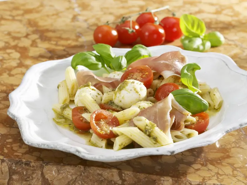 Tomaten-Nudelsalat mit Mozzarella, Rohschinken und Pesto