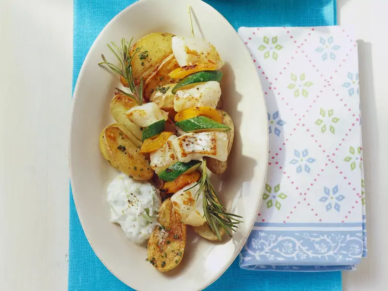 Rotbarschspieße mit Gemüse, gebackenen Kartoffeln und Gurkenjoghurt