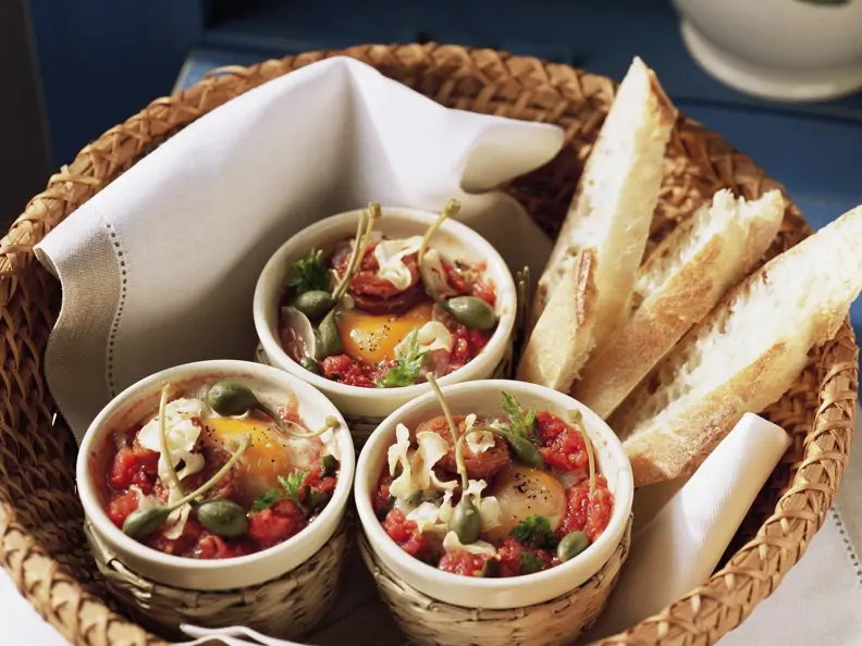 Kleine Eierpfannen mit Kapern und Tomaten dazu Weißbrot