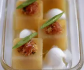 Melonenhäppchen mit Lachstatar, Lauchzwiebeln und Schmand
