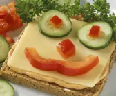 Witziger Toast mit Käse und Gemüsegesicht