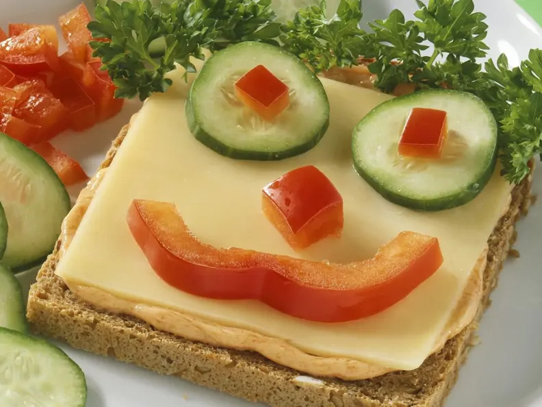 Witziger Toast mit Käse und Gemüsegesicht