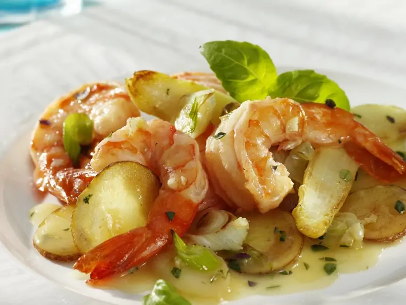 Gebratener Spargel mit Garnelen auf weißem Teller