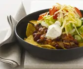 Tortilla-Chips mit Bohnen, Sauerrahm, Käse und Tomaten