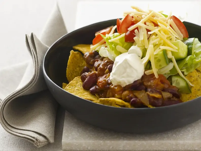 Tortilla-Chips mit Bohnen, Sauerrahm, Käse und Tomaten
