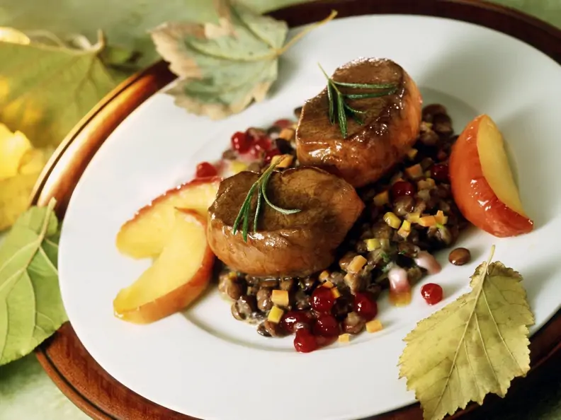 Rehsteaks auf Linsen mit Speck dazu Apfelstücke und Preiselbeeren