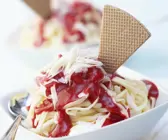 Spaghetti-Eis mit Erdbeersoße und weißen Schokoraspeln