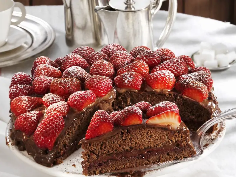 Schokoladenkuchen mit Erdbeeren angeschnitten auf Tortenheber