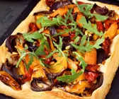 Gemüsepizza mit Rucola auf dem Blech