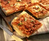 Pizza vom Blech mit Tomaten und Zwiebeln