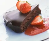 Saftiger Schokoladenkuchen mit Glasur und Erdbeeren angeschnitten