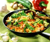 Reis-Gemüsepfanne mit Paprika im Hintergrund