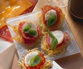 Spaghettinester mit Tomaten, Mozzarella und Salami