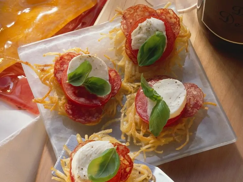 Spaghettinester mit Tomaten, Mozzarella und Salami