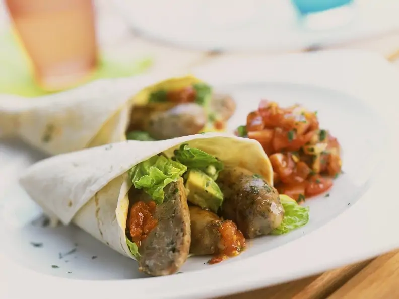 Wraps mit Bratwürstchen, Salsa und Avocado gefüllt