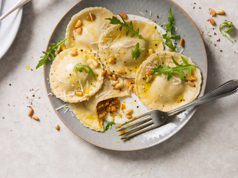 Kürbis-Ravioli mit Pinienkernen und Rucola