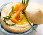 Kürbissuppe mit Garnelen und Kokosmilch in Kokosnuss