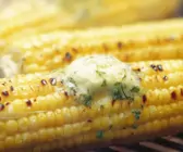 Maiskolben mit Kräuterbutter auf dem Grill