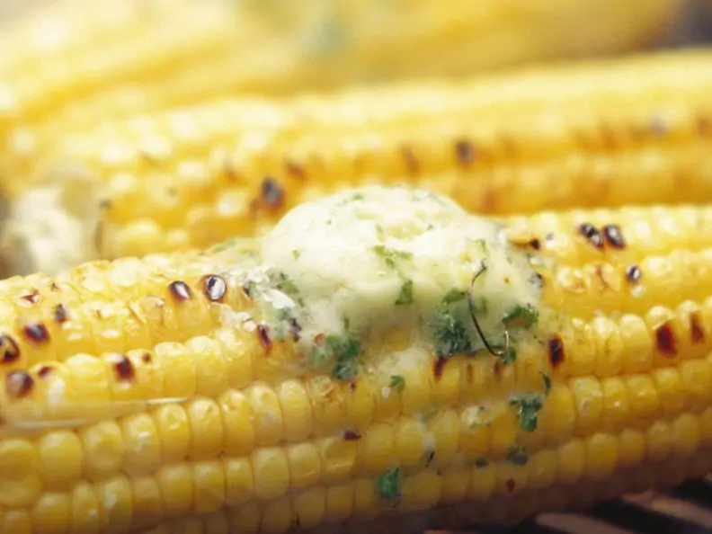 Maiskolben mit Kräuterbutter auf dem Grill