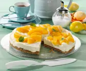 Weiße Schoko-Frischkäse-Torte mit Pfirsichen auf Krümelboden